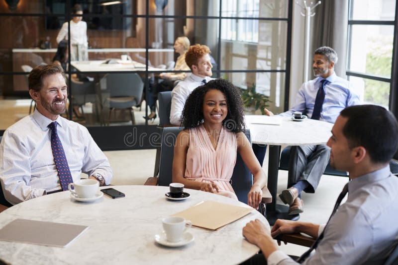 Drie het werkcollega's die bij hun bureaukoffie spreken royalty-vrije stock fotografie Drie het werkcollega's die bij hun bureaukoffie spreken royalty-vrije stock fotografie