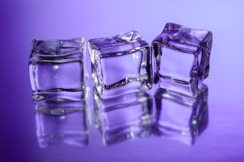 Drie ijsblokjes op glasoppervlakte met violette gradiëntachtergrond stock fotografie Drie ijsblokjes op glasoppervlakte met violette gradiëntachtergrond stock fotografie