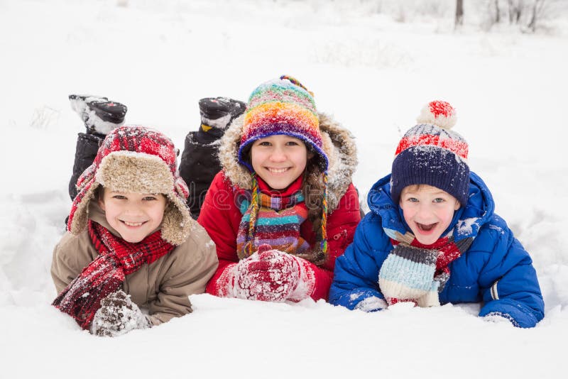 Drie jonge geitjes die samen op de wintersneeuw liggen stock fotografie Drie jonge geitjes die samen op de wintersneeuw liggen stock fotografie