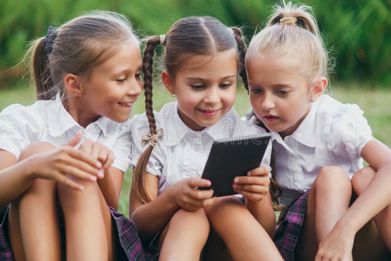 Drie Meisjes Zitten Op Het Gras En Lezen Een Ebook Leerlingen Van Lage School Begin Van Lessen 