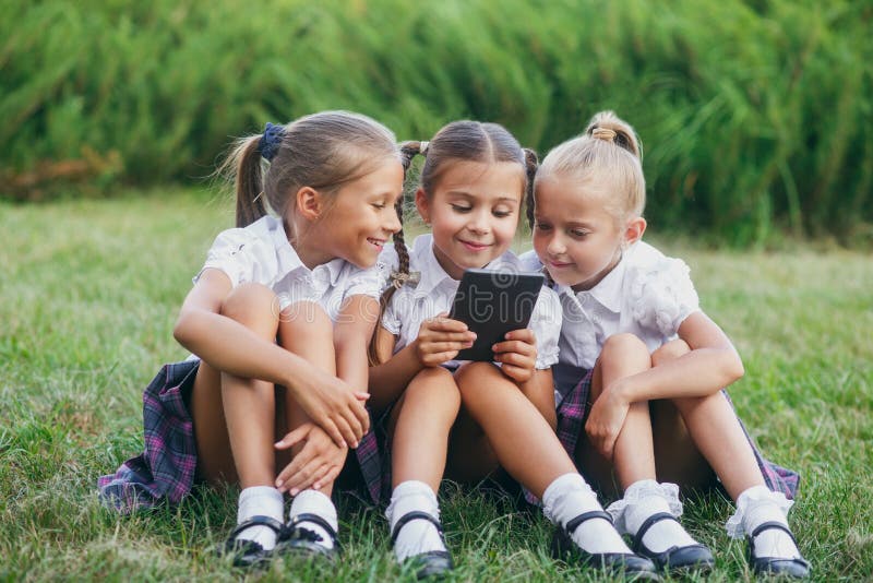 Drie Meisjes Zitten Op Het Gras En Lezen Een Ebook Leerlingen Van Lage School Begin Van Lessen 