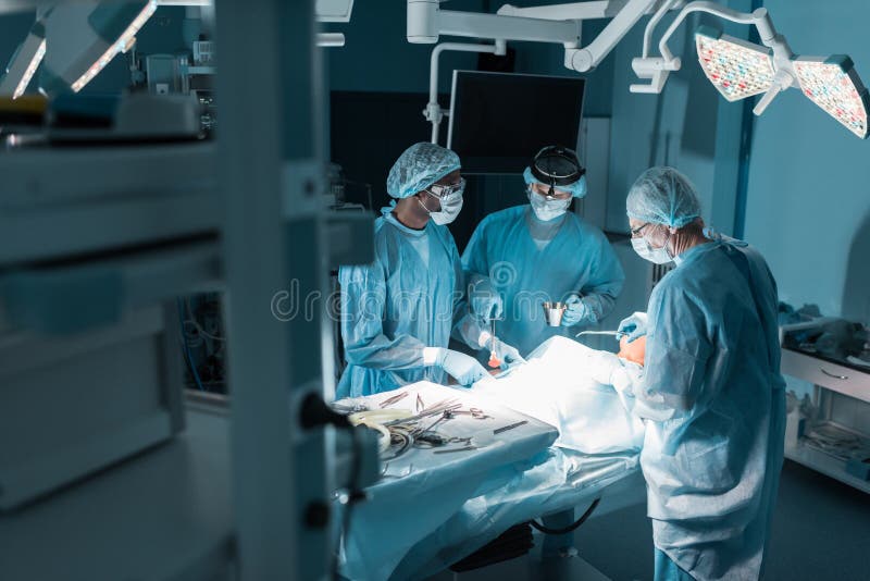 drie multiculturele chirurgen en patiënt stock afbeeldingen drie multiculturele chirurgen en patiënt stock afbeeldingen