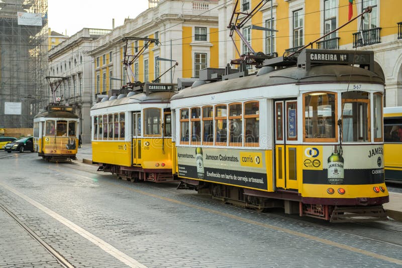 Drie typische gele die trams op Handelsvierkant worden geparkeerd in Lissabon stock foto Drie typische gele die trams op Handelsvierkant worden geparkeerd in Lissabon stock foto