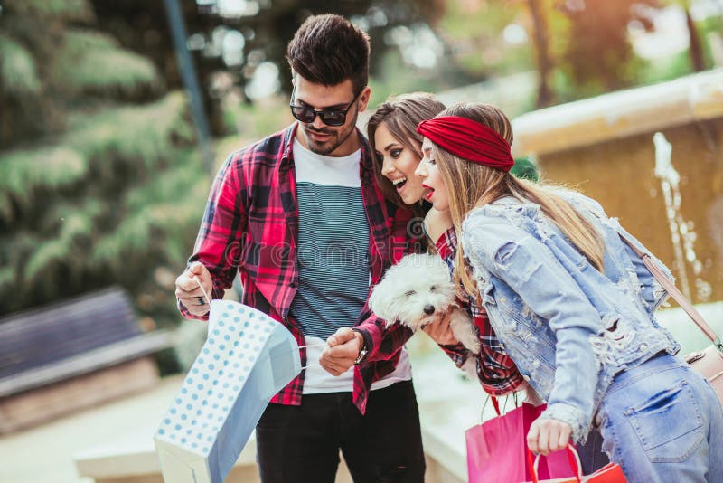 Drie vrienden die gekleurde zakken in hand houden stock fotografie Drie vrienden die gekleurde zakken in hand houden stock fotografie