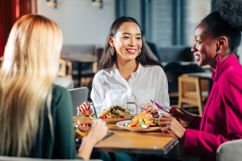 Drie vrienden die heerlijke salades in hun favoriet restaurant eten stock afbeelding Drie vrienden die heerlijke salades in hun favoriet restaurant eten stock afbeelding