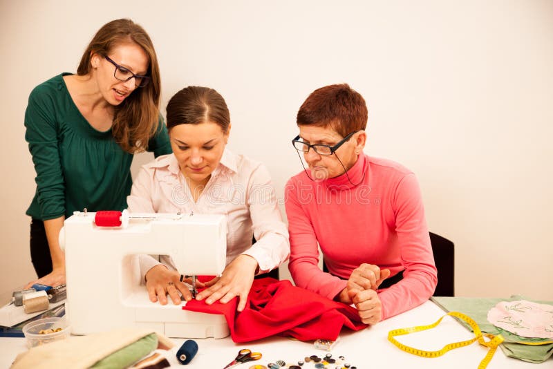 Drie vrouwen naaien op handcraftworkshop Zij onderwijzen royalty-vrije stock afbeelding Drie vrouwen naaien op handcraftworkshop Zij onderwijzen royalty-vrije stock afbeelding