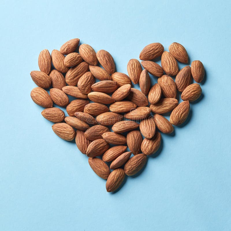 Pattern in the form of heart from almonds on a blue paper background