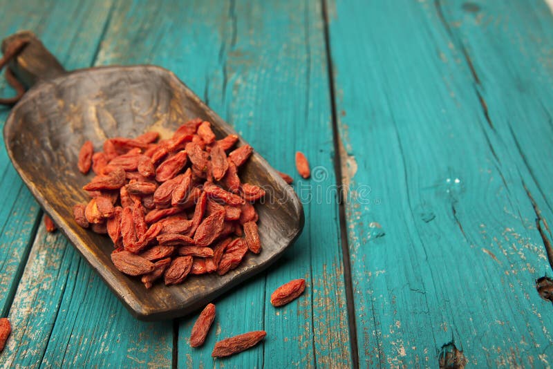 Dried goji berries in rustic wooden spoon