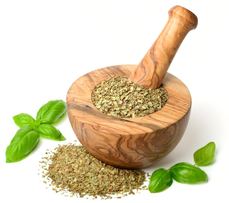 Dried herb, basil leaves in the wooden mortar, isolated on white