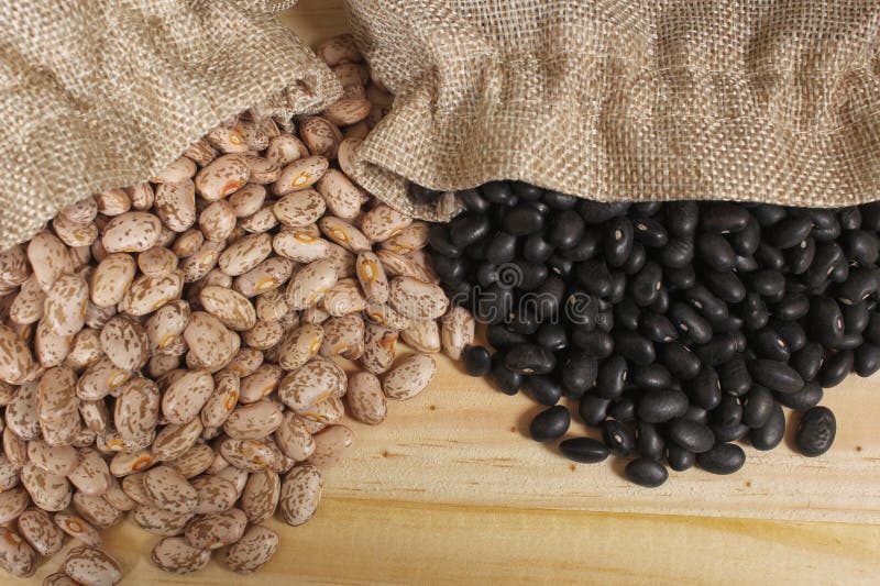 Dried Pinto Beans and Black Beans in Burlap Bag on Wooden Background