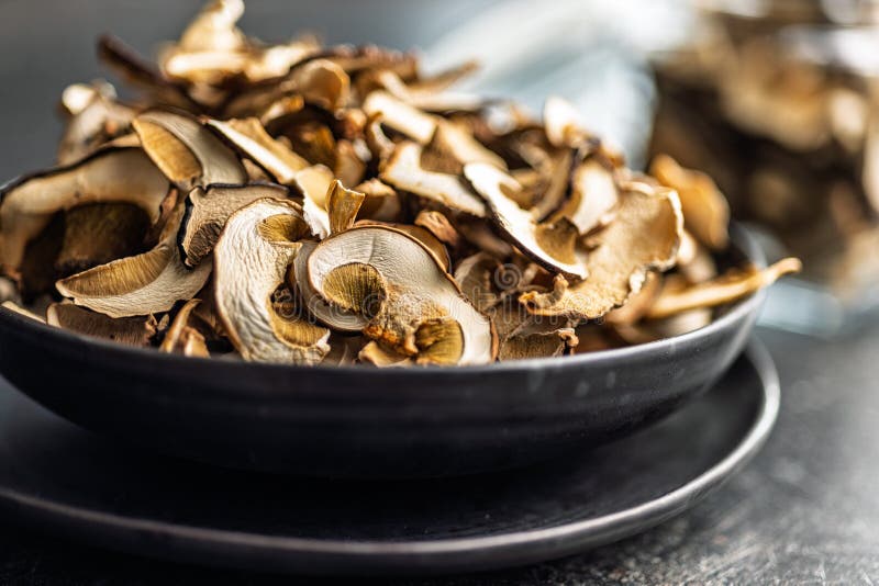 Dried porcini mushrooms. Sliced boletus on plate on black table royalty free stock photo