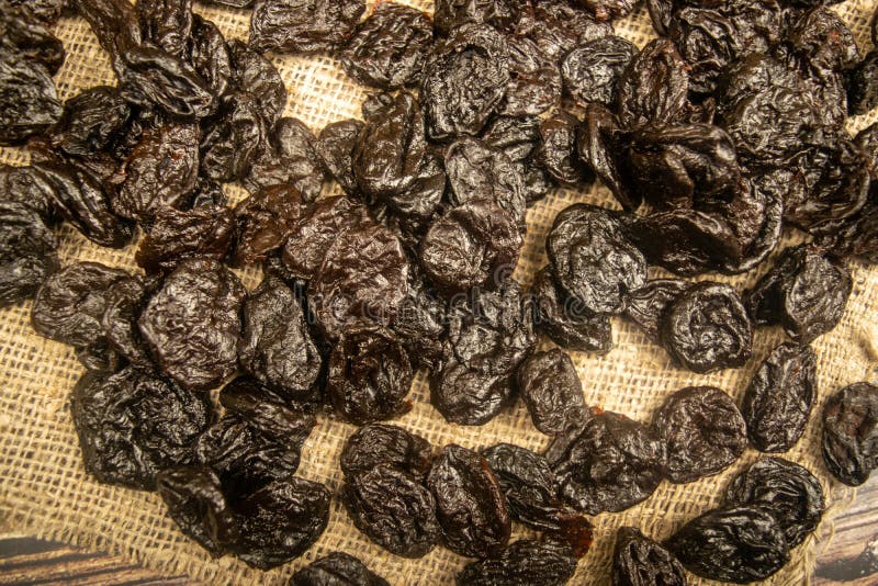Dried Prunes in Bulk on Burlap with a Rough Texture. Close Up Stock