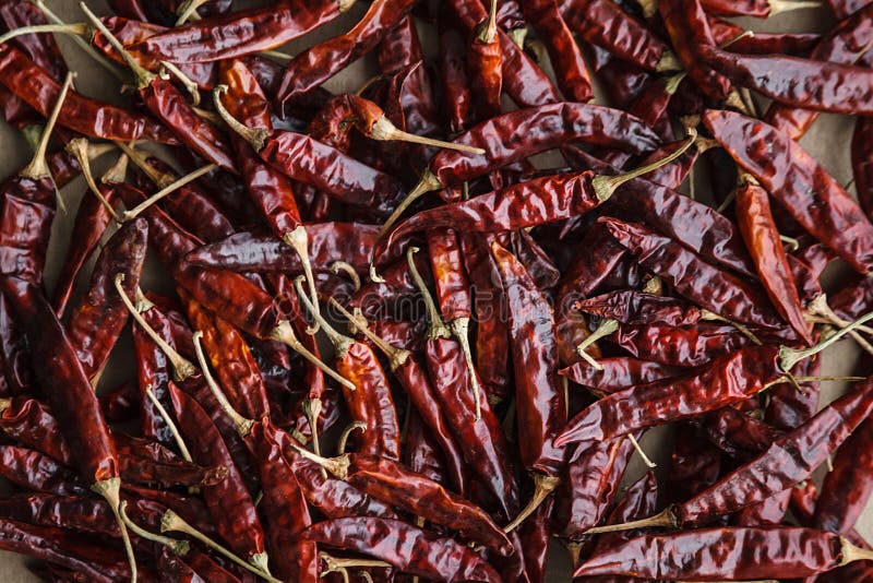 9Dried red hot chilli peppers on craft paper background.