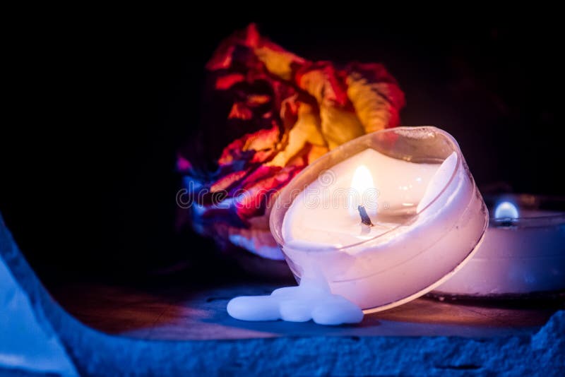 Dried Rose with Melted Tea Light Candle in Moody Atmosphere Stock Image
