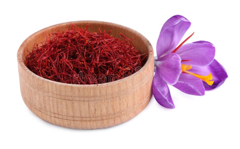 Dried saffron in wooden bowl and crocus flower on white background royalty free stock photo
