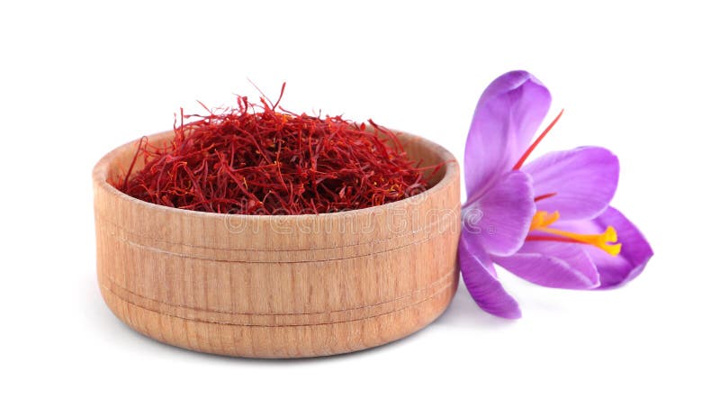 Dried saffron in wooden bowl and crocus flower on white background stock photo