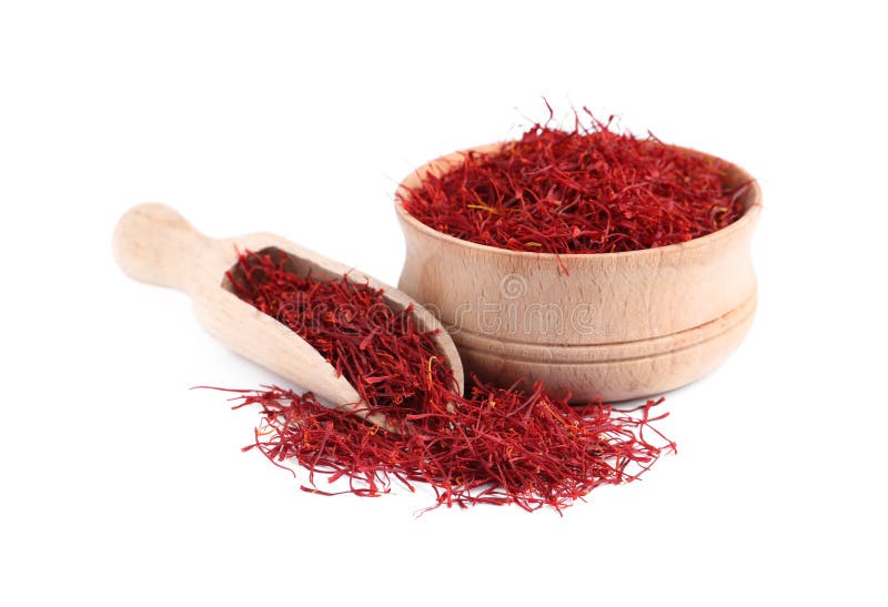 Dried saffron, wooden bowl and scoop on white background royalty free stock photos