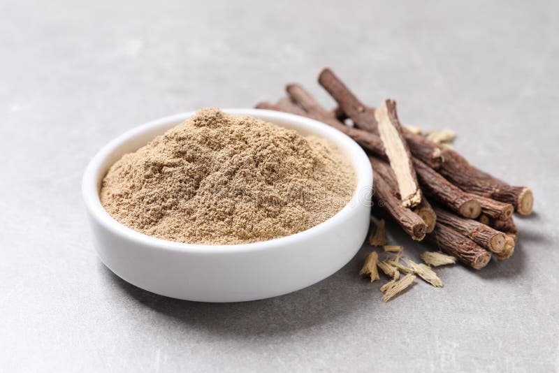 Dried Sticks of Liquorice Root and Powder on Grey Table, Closeup Stock