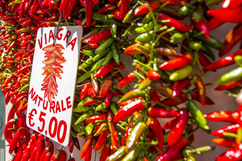 Fresh red and green hot chili peppers hanging with sale at price of `Natural Viagra` - best souvenir from Amalfi, with blurred focus, Amalfi Coast with Gulf of Salerno, Campania, Italy. Fresh red and green hot chili peppers hanging with sale at price of `Natural Viagra` - best souvenir from Amalfi, with blurred focus, Amalfi Coast with Gulf of Salerno, Campania, Italy.