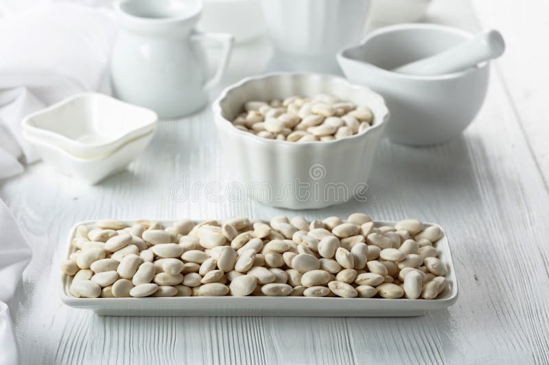 Dried white beans on a white table stock photography