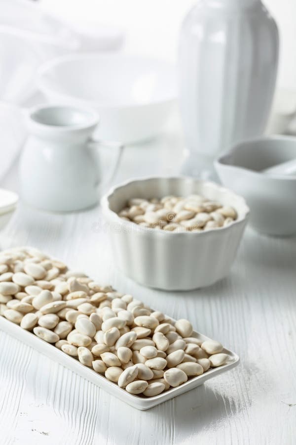Dried white beans on a white table stock photos
