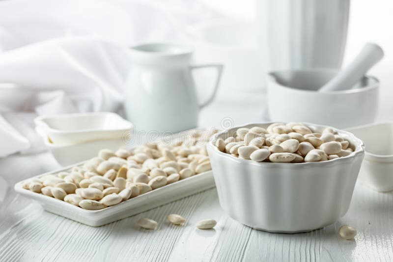 Dried white beans on a white table stock photos