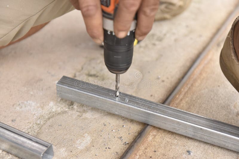 Drill Steel Pipe Using by Hand Drill in Metal Stock Image
