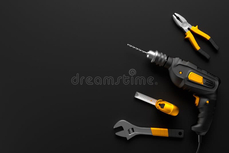 Drill, wrench and construction tools on the black background