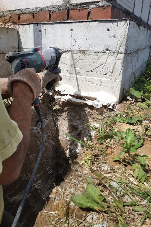 Drilling a Hole in the Concrete Wall with a Jackhammer, Perforator in