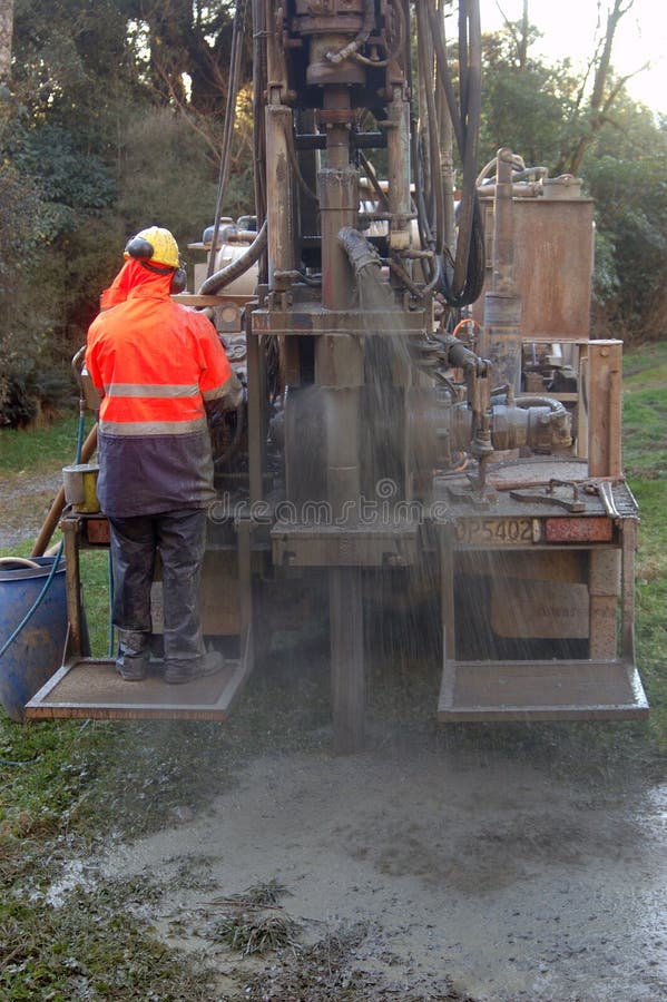 Man operating small drilling rig for water well. Man operating small drilling rig for water well