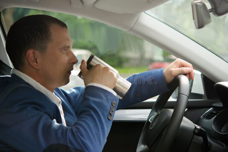 Drink coffee at the wheel of a car royalty free stock photography Drink coffee at the wheel of a car royalty free stock photography