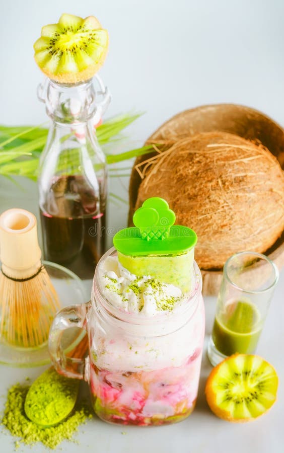 Drink för strikt vegetarianMatcha fusion med matchaglass i exponeringsglaskrus och ingredienser: matchaespresso, röd fruktfruktsa arkivbilder Drink för strikt vegetarianMatcha fusion med matchaglass i exponeringsglaskrus och ingredienser: matchaespresso, röd fruktfruktsa arkivbilder