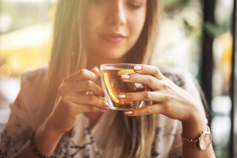 Drink Tea relax cosy photo with blurred background. Female hands holding mug of hot Tea in morning. Young woman relaxing tea cup