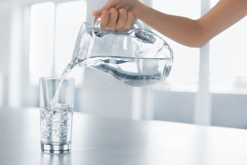 Drink water De Hand Gietend Water van de vrouw van Waterkruik in een Glas