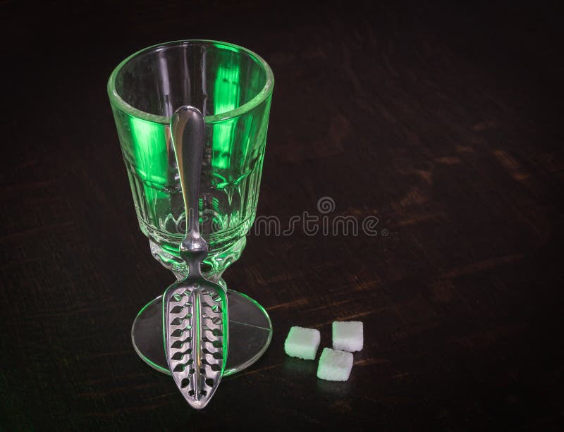 Traditional Absinthe Glass and Spoon with Sugar Cubes on Wooden Table