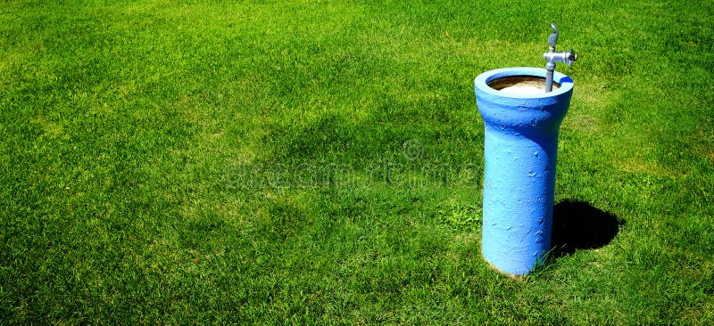 Drinking Fountain in Park on Lush Green Grass royalty free stock images