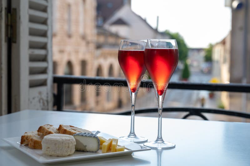 Drinking of Kir Royal,  French aperitif cocktail made  from creme de cassis topped with champagne, typically served in flute glass