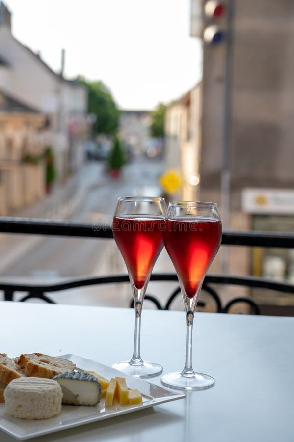 Drinking of Kir Royal,  French aperitif cocktail made  from creme de cassis topped with champagne, typically served in flute glass