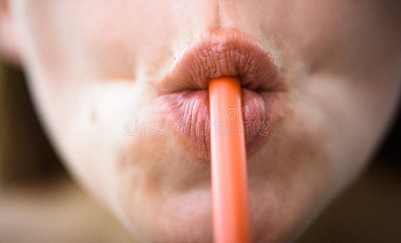 Sip of freshness. Drinking straw in mouth. Sipping drink through straw.  Female lips while drinking with