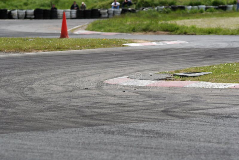 Slalom motorsport circuit used for drift competitions. The tarmac is covered with tyre marks. Focus is on the first corner apex kerb. Slalom motorsport circuit used for drift competitions. The tarmac is covered with tyre marks. Focus is on the first corner apex kerb.