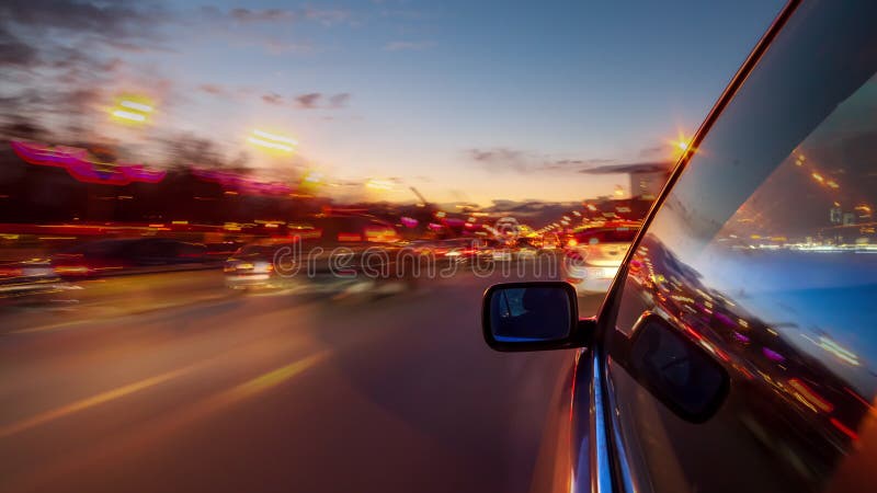 Urban look from fast driving car at a night avenue in a city time lapse.