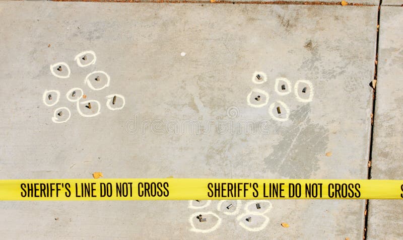 Spent cases from various guns at a drive-by shooting crime scene with Sheriff's tape. Spent cases from various guns at a drive-by shooting crime scene with Sheriff's tape