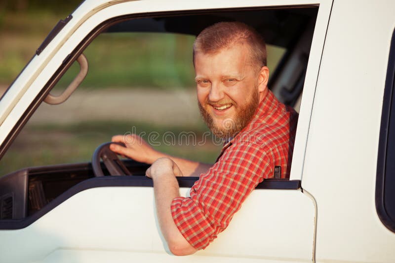 Sorridente driver in camicia rossa durante la guida.