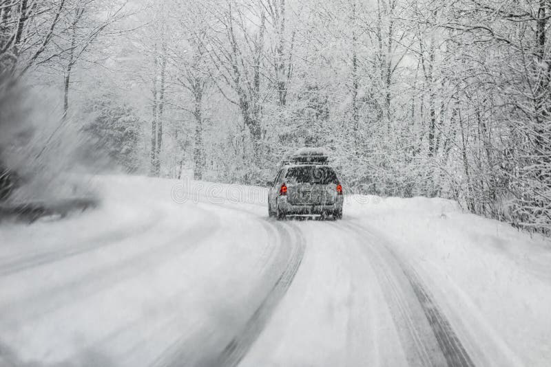 La guida in auto durante l'inverno, la neve prese con un parabrezza coperto con sfocata fiocchi di neve.