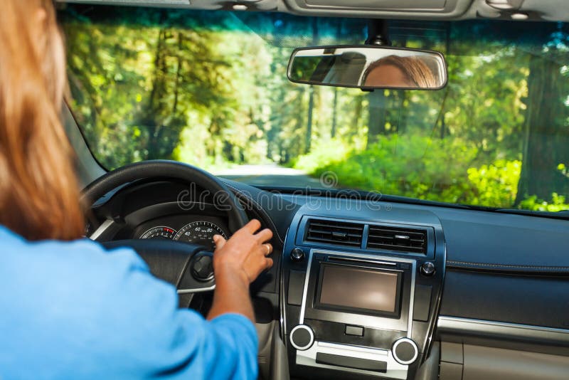 Driving woman inside the car with forest view
