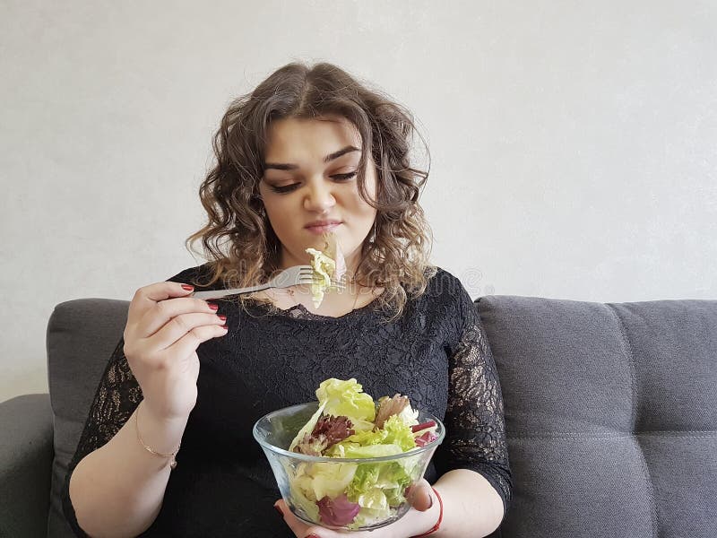 Droevig volledig mooi meisje op bank met salade gedeprimeerd ongelukkig schoteldieet royalty-vrije stock foto Droevig volledig mooi meisje op bank met salade gedeprimeerd ongelukkig schoteldieet royalty-vrije stock foto