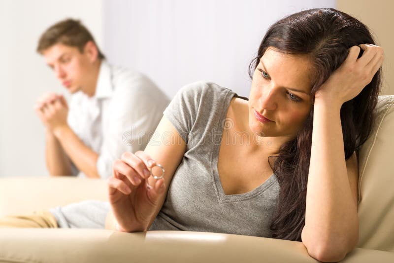 Droevige vrouw die haar ring bekijken stock foto Droevige vrouw die haar ring bekijken stock foto