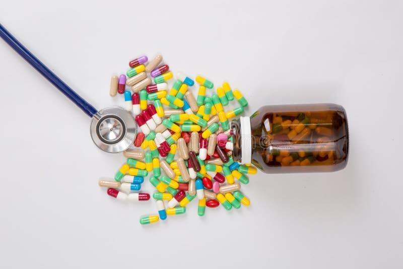 Droga che versa dalla bottiglia con lo stetoscopio immagini stock libere da diritti Droga che versa dalla bottiglia con lo stetoscopio immagini stock libere da diritti