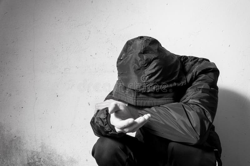 Droga sin hogar del hombre del mendigo y adicto al alcohol que se sienta solamente y deprimido en la calle en la ropa del inviern fotos de archivo libres de regalías Droga sin hogar del hombre del mendigo y adicto al alcohol que se sienta solamente y deprimido en la calle en la ropa del inviern fotos de archivo libres de regalías