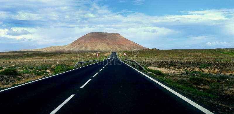 Isle of Fuerteventura Spain. One of the many extinct volcanoes that can be encountered on the drifting road and offshore on the island, Fuerteventura, from a geologic point of view, is considered to be the oldest in the Canaries. Its strange form was created by a series of volcanic eruptions thousands of years ago. Isle of Fuerteventura Spain. One of the many extinct volcanoes that can be encountered on the drifting road and offshore on the island, Fuerteventura, from a geologic point of view, is considered to be the oldest in the Canaries. Its strange form was created by a series of volcanic eruptions thousands of years ago.